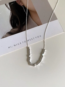 Detail of S925 sterling silver necklace with geometric cube pendants on minimalist chain