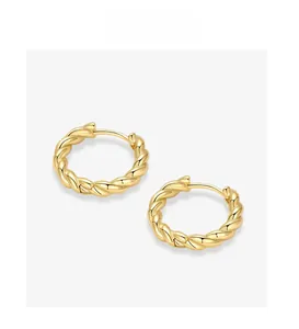 Close-up of golden twisted rope earrings showing detailed metallic texture and shine