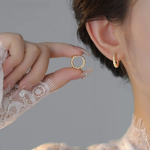 Elegant twisted gold hoop earrings for women with high-shine metallic texture finish