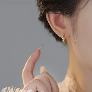 Elegant gold twisted hoop earrings with textured metal weave for a stylish minimalist look