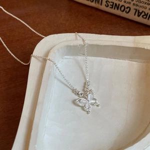Détail du collier papillon avec des ailes en opale et des accents argentés