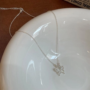 Détail du collier papillon en opale avec incrustation de zircons sur plateau céramique