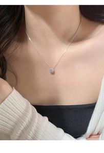 Detailed view of s925 silver necklace with square pavé diamond pendant on a model collarbone