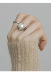 Detailed macro view of vintage S925 silver ring with large white pearl and floral carving