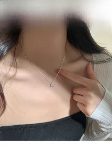 Close-up of square pendant necklace with silver chain shown on model neck