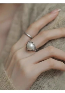 Detail of vintage silver pearl ring with woven texture and retro carved craftsmanship