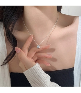 Close-up of S925 sterling silver square halo pendant necklace on model's neck