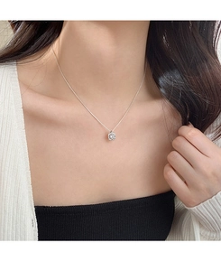 Close-up of a s925 sterling silver necklace with a square-cut cubic zirconia on a model