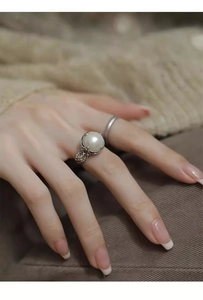 Detail view of S925 silver ring with large white pearl and vintage hollow carved design