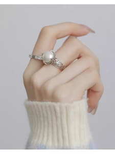 Close-up of S925 silver pearl ring with hollow pattern and zircons on model hand