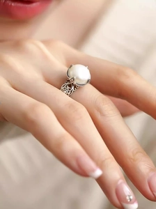Macro shot of S925 silver ring featuring a large white pearl and hollow floral engraving