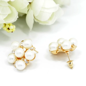 Vue détaillée des boucles d'oreilles perles avec strass blancs et finition dorée