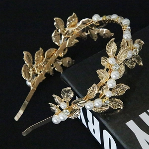 Close-up of golden leaf headband with delicate pearls and sparkling rhinestones