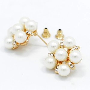 Vue détaillée des boucles d'oreilles perles en fleur avec base dorée et strass