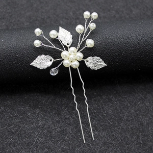 Elegant bridal hair pin with silver leaf design and pearl flower on a black display stand