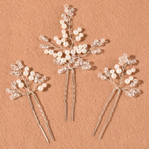 Macro shot of 3-piece handmade pearl and crystal bridal hair pins on velvet background