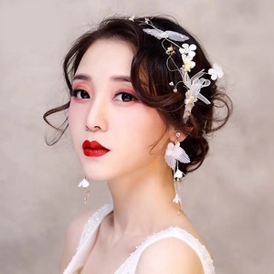 Détail de serre-tête nuptial et boucles d'oreilles à pompons avec pétales blancs et fil doré