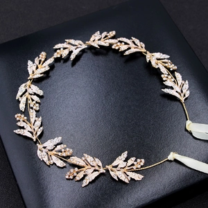 Dettaglio della fascia da sposa a foglie dorate con strass su scatola da esposizione