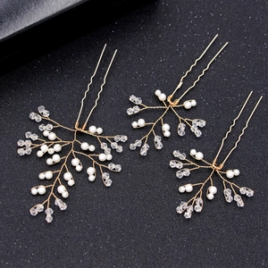 Handmade gold bridal hair pin set with white pearls and crystals on black background