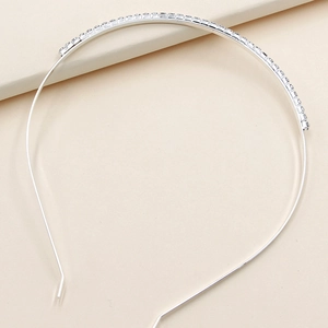 Close-up of sparkling rhinestones on a slim silver alloy bridal headband for weddings