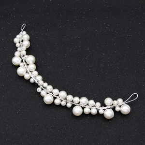 Détail macro d'un serre-tête de mariée fait main avec perles d'ivoire et fil argenté