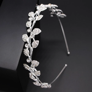 Macro side view of silver bridal tiara featuring detailed leaf patterns with rhinestones