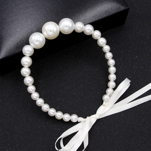 Collier élégant en perles blanches dégradées avec ruban en soie sur fond noir mat