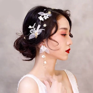 Détail de serre-tête de mariée avec fleurs en tulle blanc et boucles d'oreilles