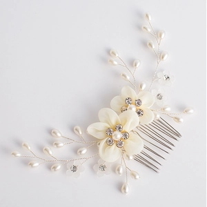 Detail of handmade bridal hair comb with ivory fabric flowers and pearl branches