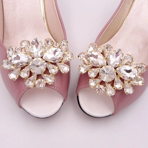 Détail de boucles fleurs en cristal étincelant sur des escarpins de mariée roses