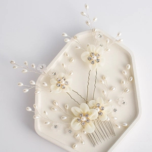Macro detail of ivory fabric flower hair comb set with white pearls and crystals