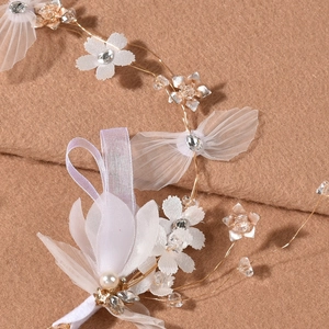 Détail macro d'une coiffe de mariée avec fleurs en mousseline et papillons en tulle