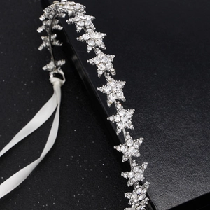 Détail de strass en étoile sur couronne argentée avec ruban de satin blanc pour mariée