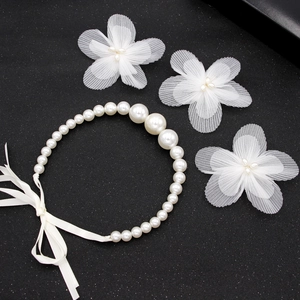 Ensemble détaillé de fleurs en organza et bandeau perles sur fond noir texturé