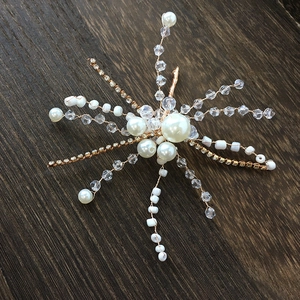 Detailed close-up of handmade bridal snowflake hairpin with pearls and crystals