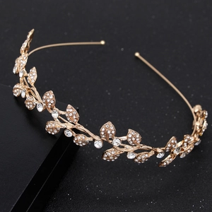 Golden bridal crown with sparkling rhinestones and leaf motifs on black background