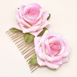 Detail of pink fabric rose hair comb featuring delicate petals and gold metal teeth