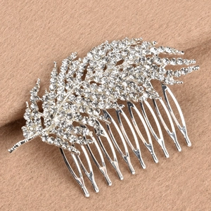 Détails d'un peigne à cheveux de mariée avec motifs de feuilles et cristaux brillants