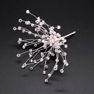 Close-up of handmade bridal snowflake hair clip with rose gold wires and clear beads