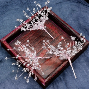 Detailed macro view of three beaded snowflake hair clips on a textured blue and wood base