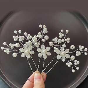 Dettaglio dei fermagli per capelli da sposa fatti a mano con perle bianche e filo d'argento