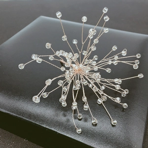 Detail of handcrafted bridal hair clip with intricate beads and silver wire snowflake design