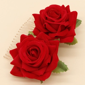 Detail of red velvet rose hair comb with green leaves on a gold metal hair clip