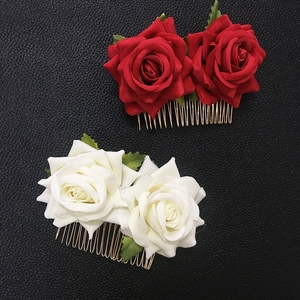 Detailed close-up of velvet red and white roses on golden metal bridal hair combs