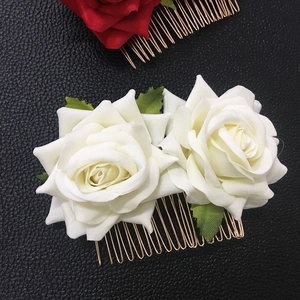 Detail view of velvet rose hair combs in red and white with gold metal teeth