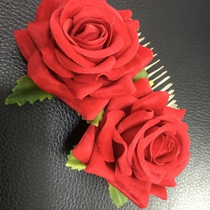 Close-up of dual red velvet rose hair comb with green leaves and gold metal prongs
