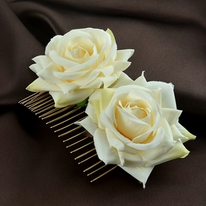 Detail view of double cream fabric roses on a gold metal bridal hair comb