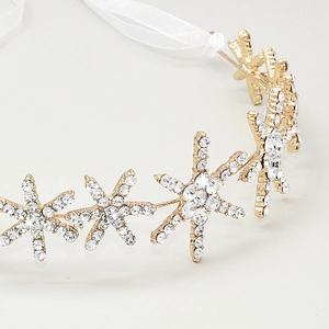 Detail shot of shimmering snowflake bridal headband with crystals and white ribbon ties