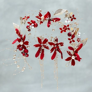 Detail of red velvet flower bridal headpiece and gold tassel earrings for weddings