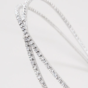 Détail d'un serre-tête de mariée argenté avec couches croisées et strass en cristal pavé